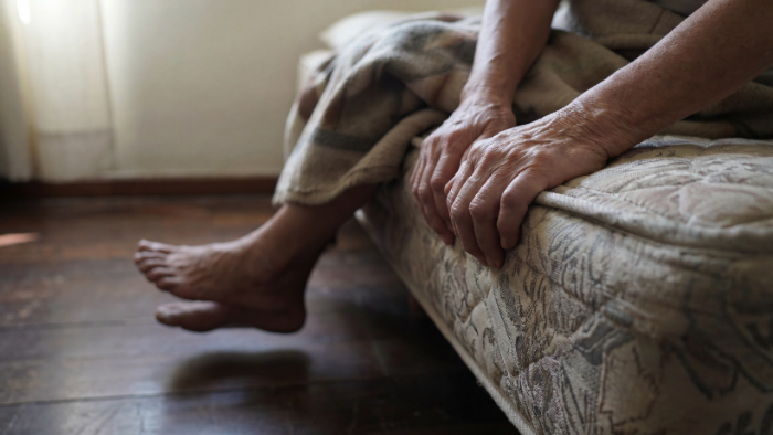 Primer plano de manos agarrando el borde de la cama — el Terror Matutino